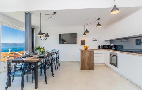 a kitchen and dining room with a table and chairs at Beautiful Home In Njivice With Wifi in Njivice