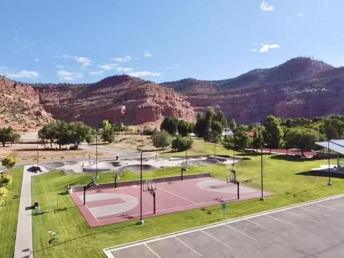 an empty tennis court with mountains in the background at Timber & Tin G 2Bed 2Bath w Pool & Rooftop Deck in Kanab