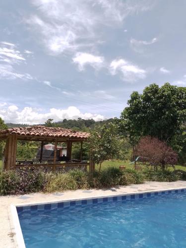 a swimming pool with a gazebo in a yard at Finca las Margaritas in Estación El Salto