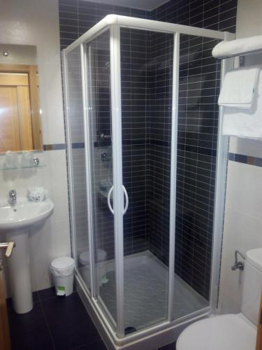 a bathroom with a shower with a toilet and a sink at Hostal Plaza Mayor de Almazán in Almazán