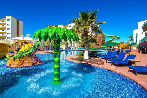 einen Pool mit Stühlen und Palmen in einem Resort in der Unterkunft Las Palmas Resort Rocky Point Mexico in Campo del Medio