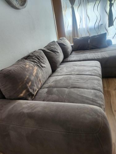 a brown couch sitting in front of a window at White Sand Haven Guest House in Ebhausen