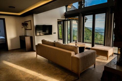 a living room with a couch and a large window at Vukanov Pogled in Sekulić 