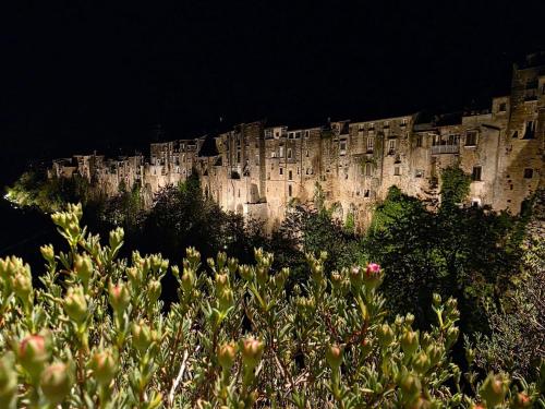 a building on the side of a mountain at night at Goti Rooms B&B in SantʼAgata deʼ Goti