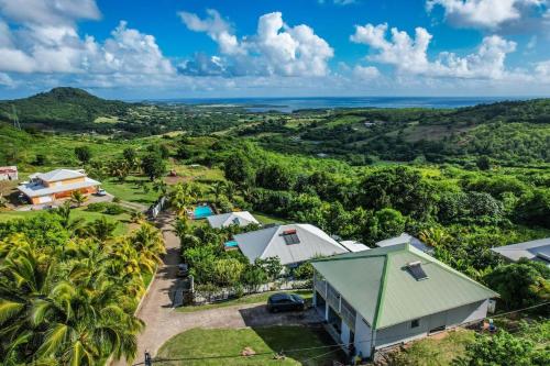 an aerial view of a resort with palm trees and the ocean at Maison typique au calme avec vue in Le Marin