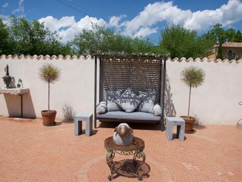 a couch with pillows sitting on a patio at La Ferme Rose-Hôtel de Charme in Moustiers-Sainte-Marie