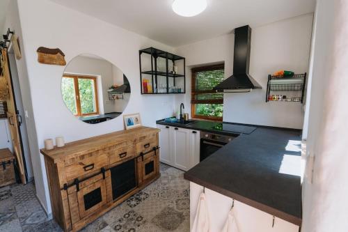 a kitchen with a counter and a sink and a mirror at Baglyashegy Vendégház in Sümeg