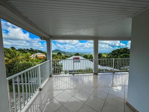 an empty porch with a view of the ocean at Maison typique au calme avec vue in Le Marin