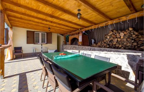 a patio with a ping pong table and a fireplace at Gorgeous Home In Rukavac With Kitchen in Rukavac