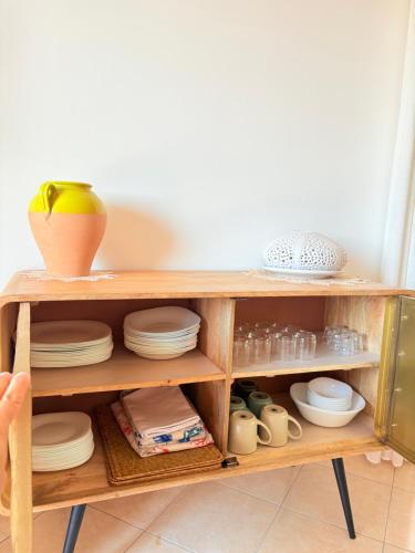 a wooden shelf with plates and dishes in it at Villaelena Salento Mare in Marittima