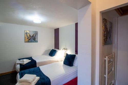 a hotel room with two beds with blue pillows at OYO The Bentleys Hotel in Newcastle upon Tyne