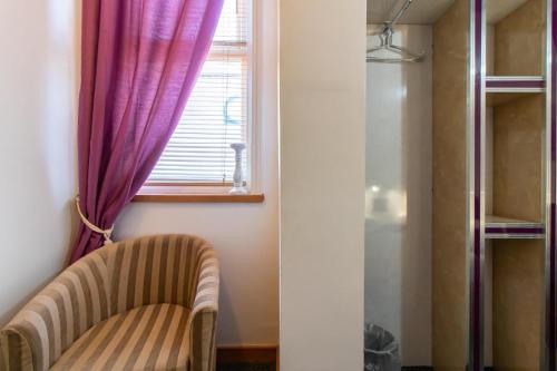 a room with a chair and a window at OYO The Bentleys Hotel in Newcastle upon Tyne