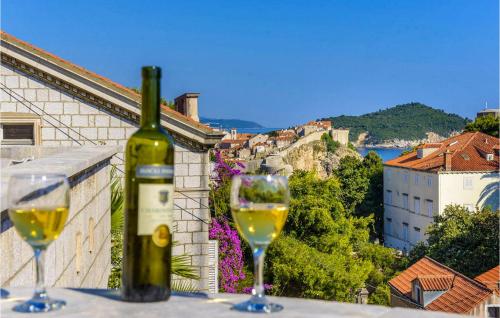 a bottle of wine sitting on a ledge with two wine glasses at Villa Mediteran in Dubrovnik
