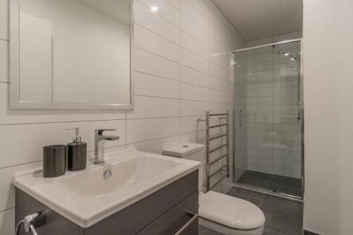 a bathroom with a sink and a toilet and a shower at 3 Bedroom Apartment in Epsom in Auckland