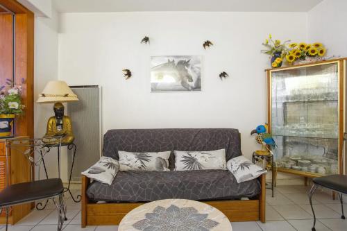 a living room with a couch and spiders on the wall at Appartement Charron - Welkeys in Bandol