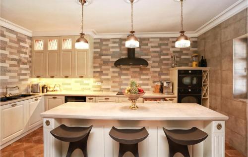 a kitchen with a large island with stools at Villa Carolus Barat in Barat