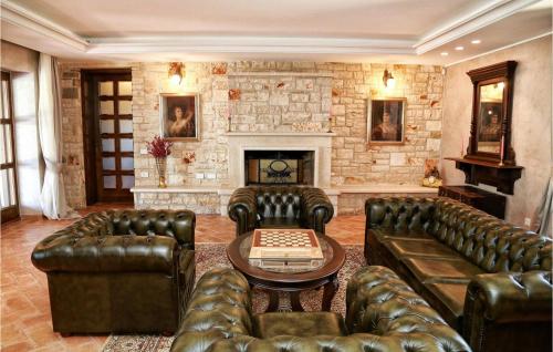 a living room with leather furniture and a fireplace at Villa Carolus Barat in Barat