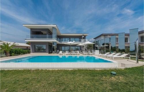 une maison avec une piscine devant une maison dans l'établissement Villa Gabrijela Kastelir, à Kaštelir