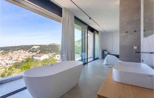 a bathroom with a large white tub and a large window at Villa Magic Sunset in Hvar