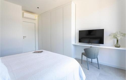 a white room with a bed and a chair and a tv at Villa Magic Sunset in Hvar