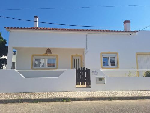 a white house with a black fence in front of it at Casa da Vila - Malhadais in Odeceixe