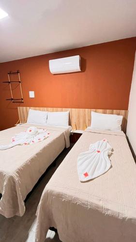 two beds sitting next to each other in a room at Casarão Suítes Maragogi in Maragogi