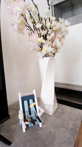 a vase with flowers and two miniature chairs and a vase with flowers at White Sand Haven Guest House in Ebhausen