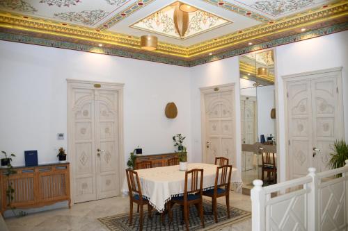 a dining room with a table and chairs and a ceiling at Dar Hamouda Guest House - Médina de Tunis in Tunis