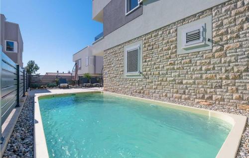a swimming pool in front of a brick building at Villa Valencan 3 in Mednjan