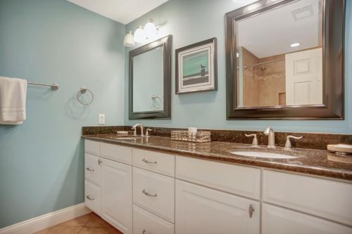 une salle de bain avec deux lavabos et un grand miroir dans l'établissement 1829 Beachside Tennis at The Sea Pines Resort, à Île de Hilton-Head