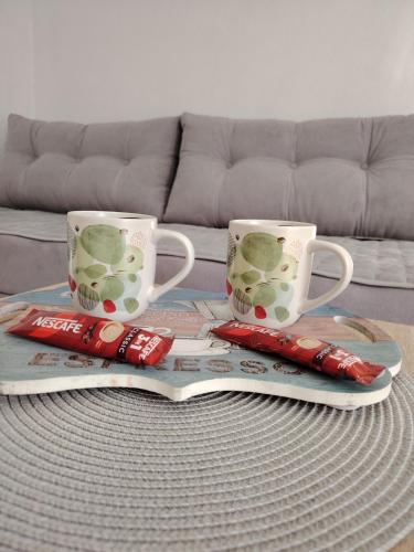 a coffee table with two cups and a tray withcigarettes at AURORA in Visoko