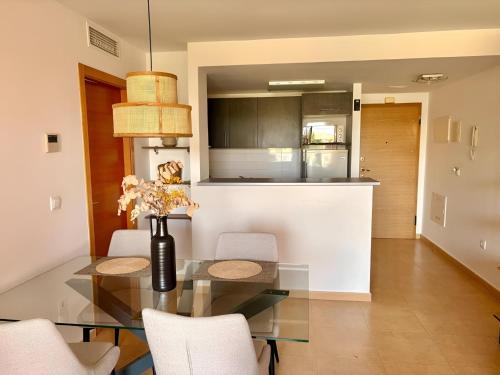 a kitchen and dining room with a glass table and chairs at Sun and Golf Holidays at Mar Menor Golf Resort in Torre-Pacheco