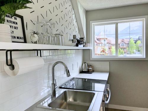 a kitchen with a sink and a window at Top Floor Mountain View Escape in Canmore