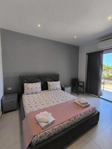 a bedroom with a large bed with two towels on it at The Darling Guesthouse in Himare