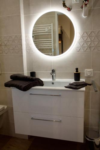 a bathroom with a white sink and a mirror at Le studio du 3bis in Anduze