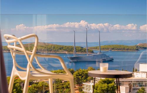 a white chair and a boat in the water at Villa Afrodita in Hvar