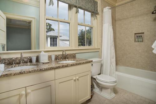 a bathroom with two sinks and a toilet and a window at 3 Bedroom Wilson Village Home 19 in Bluffton