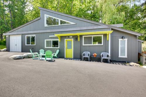 a gray house with a yellow door and chairs at Steps to Lakefront Home Near Schweitzer Mtn! in Sagle