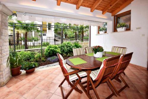 taras ze stołem i krzesłami z drewna w obiekcie Apartments in Porec - Istrien 40311 w Poreču
