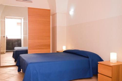 een slaapkamer met twee blauwe bedden en een raam bij Casa Caporosso Giusti in Maruggio