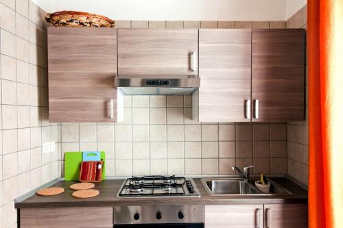 een keuken met houten kasten en een kookplaat met oven bij Casa Caporosso Giusti in Maruggio