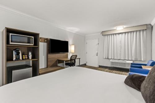 a hotel room with a bed and a flat screen tv at Signature Temecula in Temecula