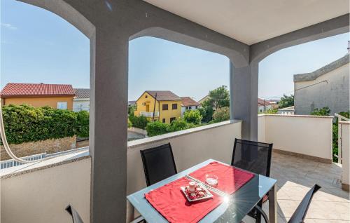 ポヴリャナにある2 Bedroom Cozy Apartment In Povljanaのバルコニーにテーブルと椅子が置かれたパティオ