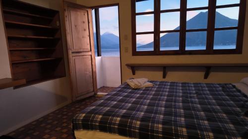 a bedroom with a bed and a window with mountains at Cuarto 2 in San Marcos La Laguna
