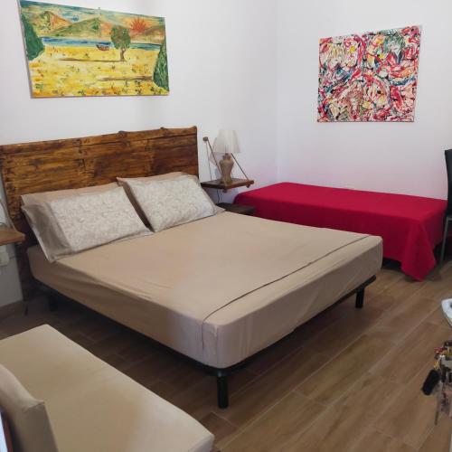 a bedroom with two beds and a red couch at B&B Al Melograno in Sant'Isidoro