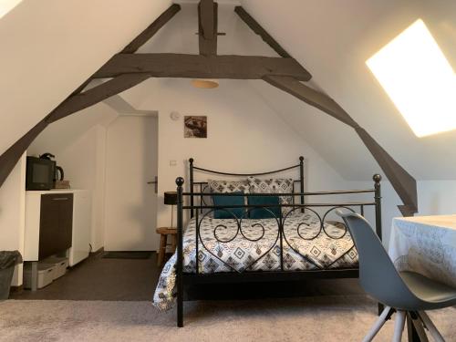 a bedroom with a bed in the attic at Chambre chaleureuse avec accès indépendant et sanitaires indépendants in La Menitré