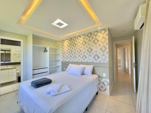 a bedroom with a large white bed with towels on it at Mandara Lanai Resort - Porto das Dunas in Aquiraz