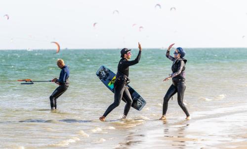 a group of three people in the water on the beach at Desert Sands Dakhla Lagoon View & Kitesurf Spot in Dakhla