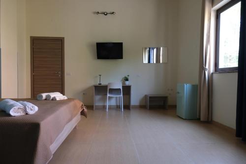 a bedroom with two beds and a desk and a television at B&B Etesia in Vibo Valentia