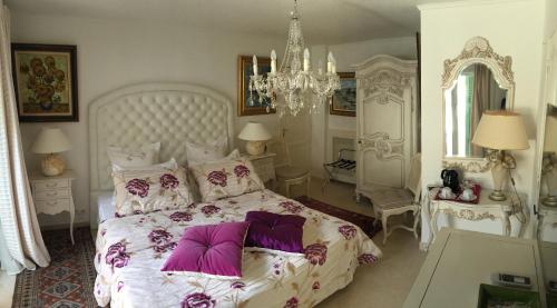 a bedroom with a large white bed with purple pillows at La Bergerie B&B in Vence